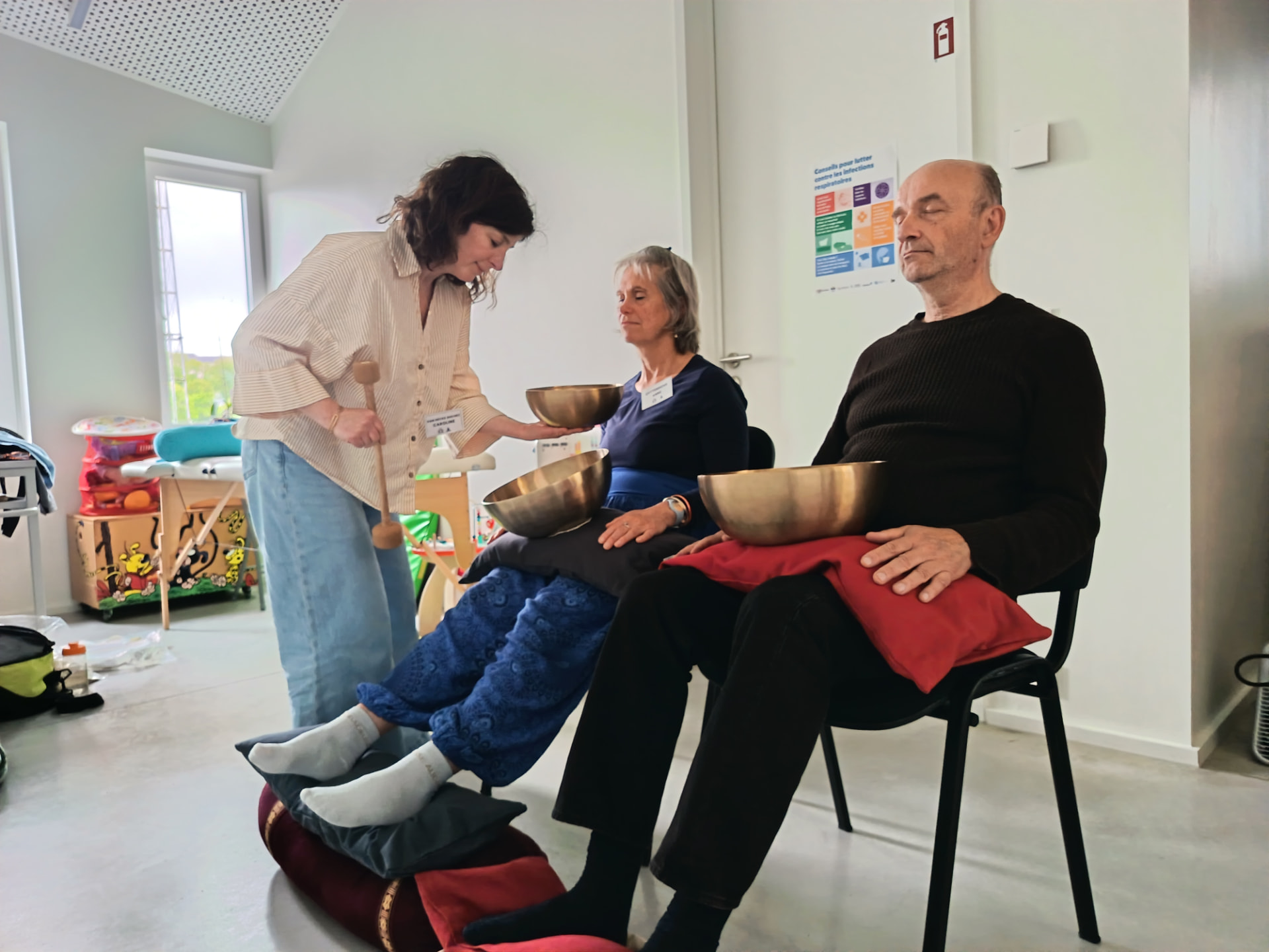 Massage sonore sur chaise auprès de deux participants en atelier