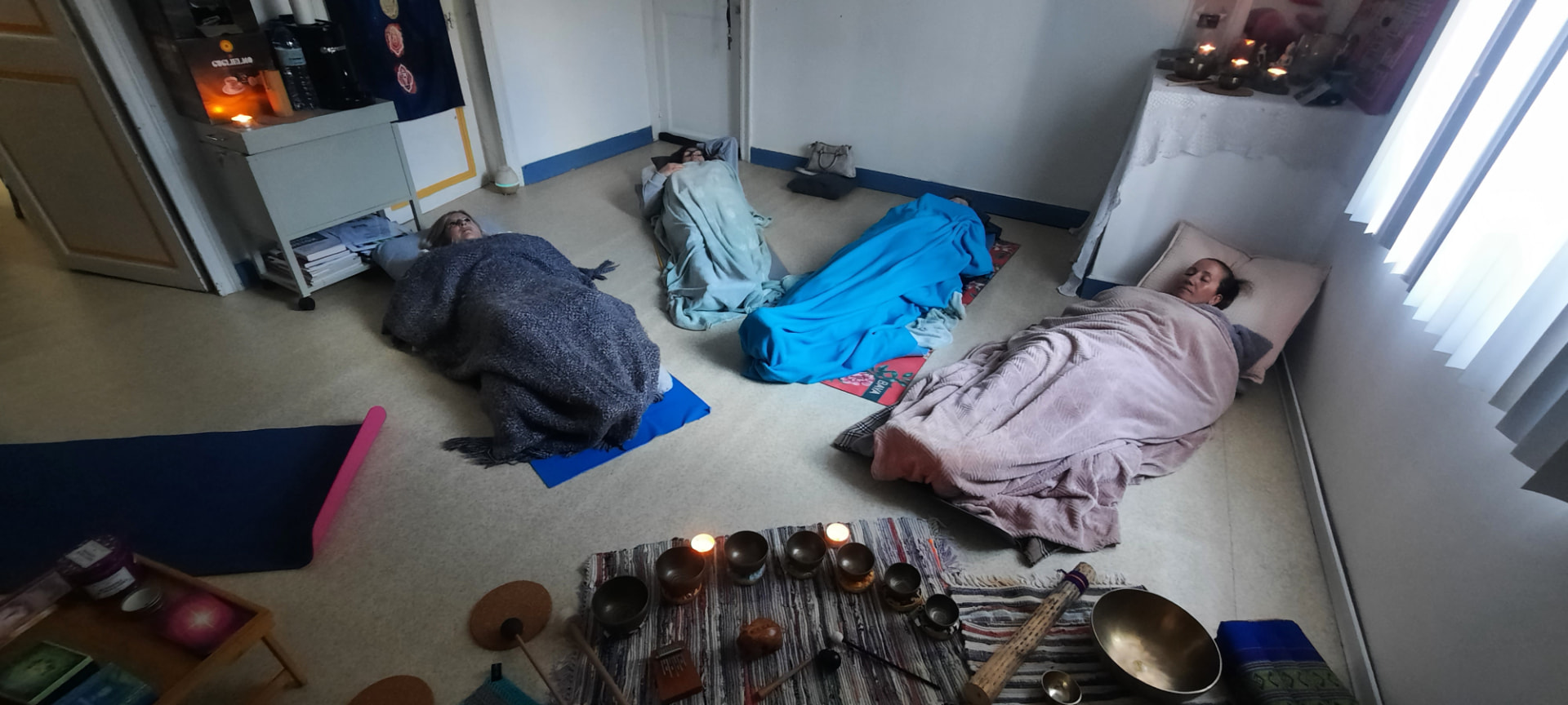 Bain sonore collectif : participantes allongées sous des couvertures autour des bols chantants