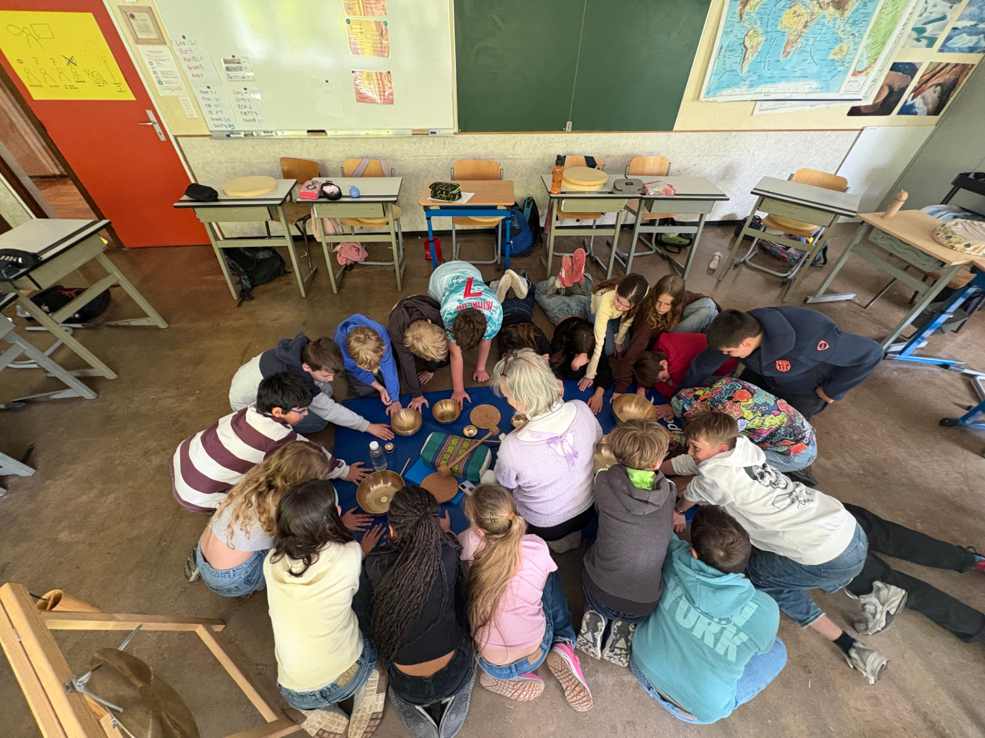 Atelier bols chantants avec une classe de 5e primaire, élèves en cercle autour des bols